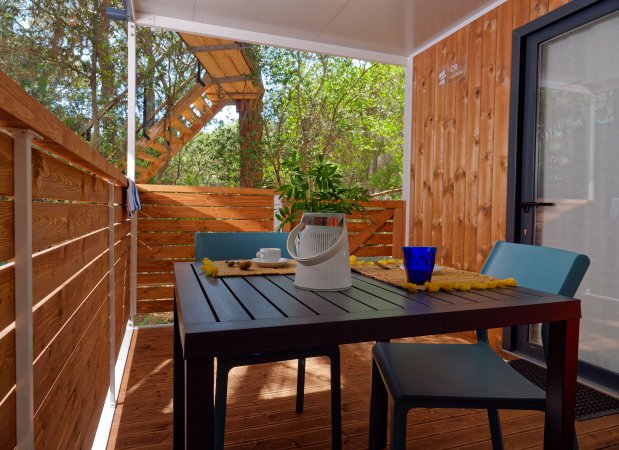 Tavolo da pranzo con decorazioni su una veranda di legno.
