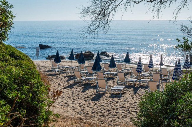 Spiaggia con ombrelloni chiusi.