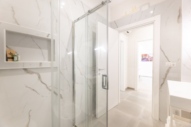 Bagno con doccia e lavandino.
