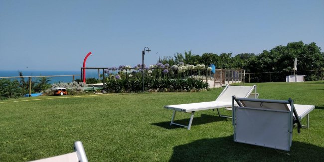 Lettini su prato verde con vista sul mare.