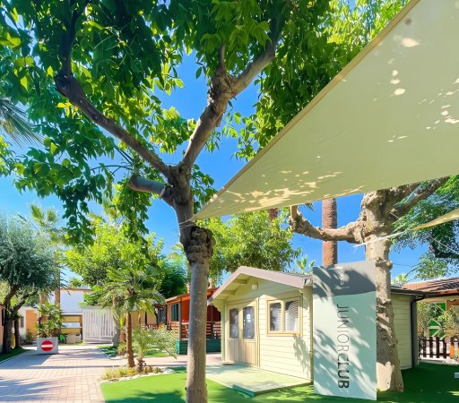Un giardino con alberi, un piccolo edificio con un'insegna 