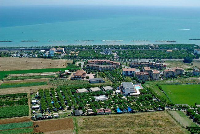 Veduta aerea di un'area costiera con campi e edifici.