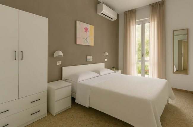 Camera da letto con pareti beige e armadio bianco.