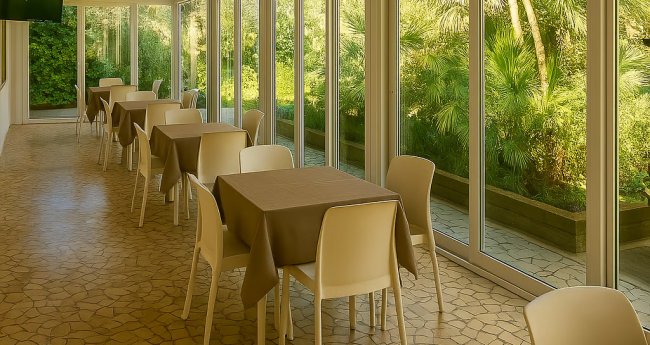 Sala da pranzo con vista su un giardino.
