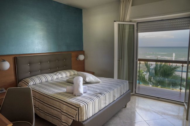 Letto matrimoniale, finestra aperta, vista mare.