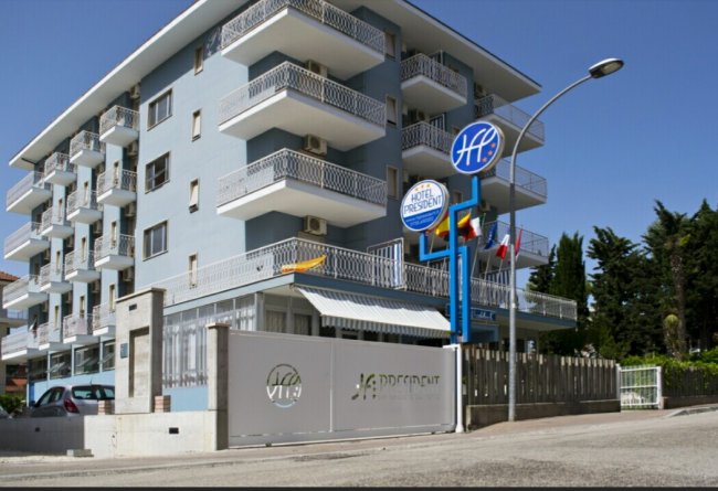 Edificio blu di un hotel con balconi e insegna 