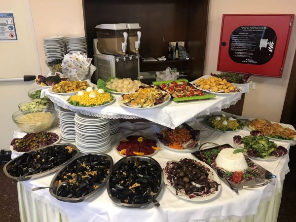 Tavolo da buffet con piatti vari, tra cui frutti di mare e verdure.