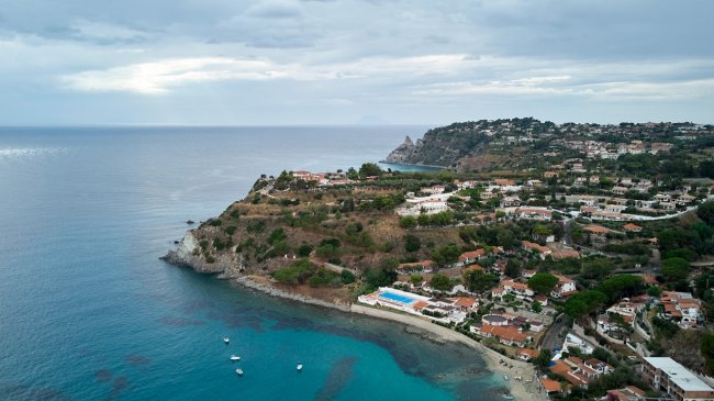 Costa con case e mare, vista dall'alto.