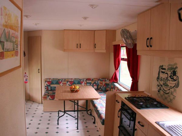 Cucina con tavolo e panchina colorati.