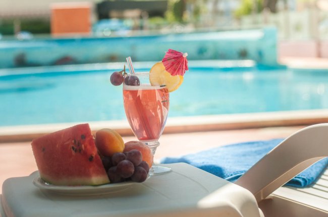 Cocktail fruttato su un tavolino vicino alla piscina.
