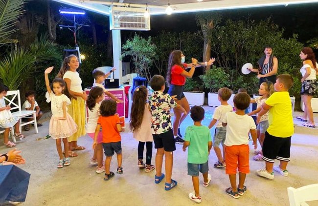Gruppo di bambini si diverte mentre ballano insieme all'aperto di sera.