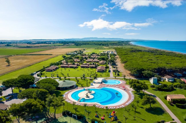 Resort con piscine azzurre contornate da prati e vista mare.