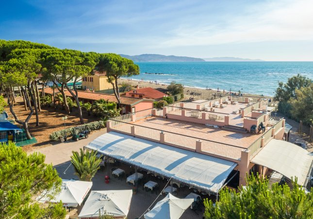 Spiaggia con edifici e alberi, vista sul mare.