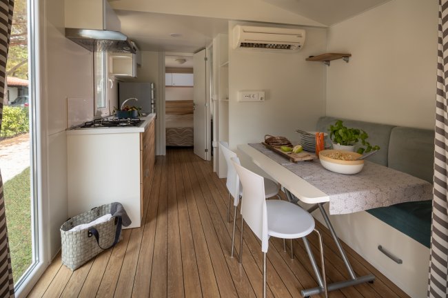Cucina moderna con tavolo, sedie e finestra aperta.