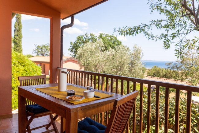 Tavolo da pranzo all'aperto con vista mare, coperto da un pergolato.