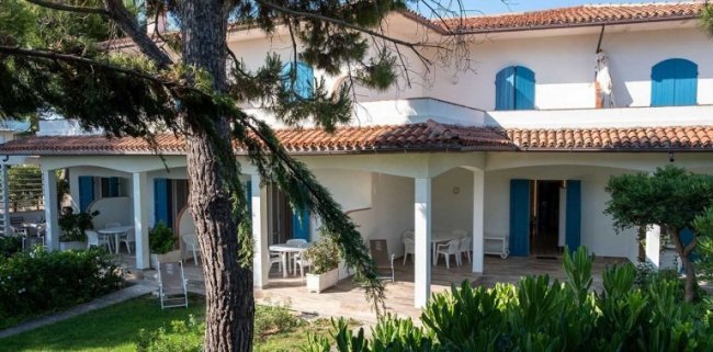 Casa bianca a due piani con giardino.