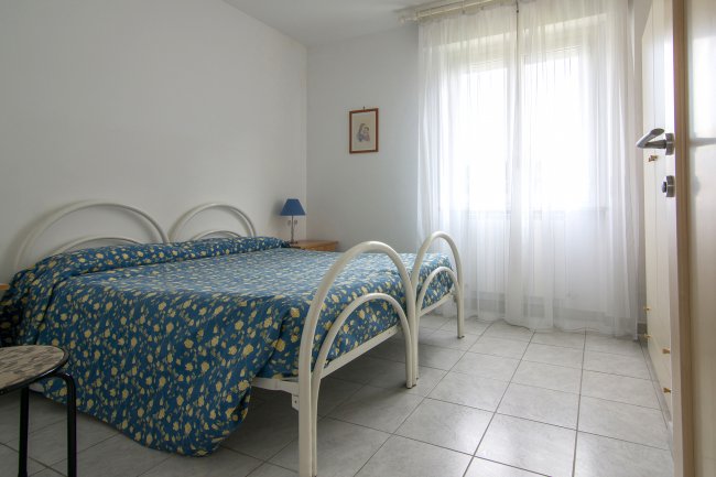 Camera da letto con letto matrimoniale e lampada blu.