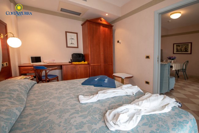 Camera d'albergo con letto matrimoniale e scrivania in legno.