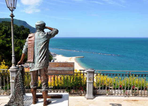 Statua di un marinaio su una terrazza con vista mare.