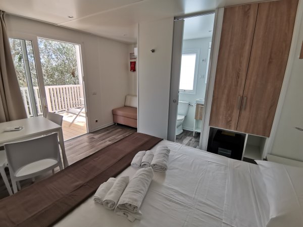 Camera da letto luminosa con accesso a un terrazzo vista bagno.