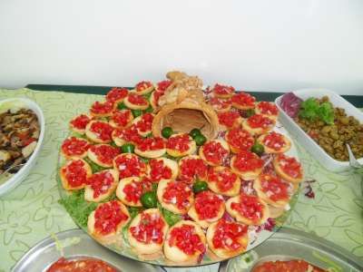 Bruschette con pomodori e olive su un piatto decorativo.