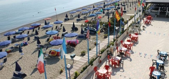 Tavoli e ombrelloni su una terrazza spiaggia.