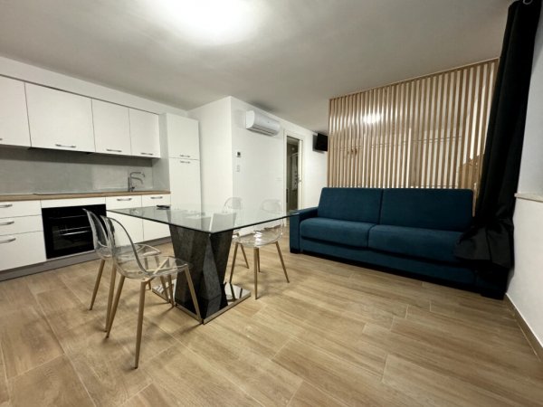 Cucina moderna con tavolo di vetro e divano.