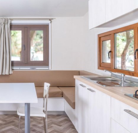 Cucina moderna con finestra, tavolo e divano angolare.