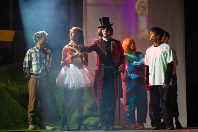 Persone in costumi teatrali colorati su un palco.