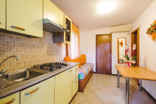 Cucina accogliente con divano arancione e tavolo.
