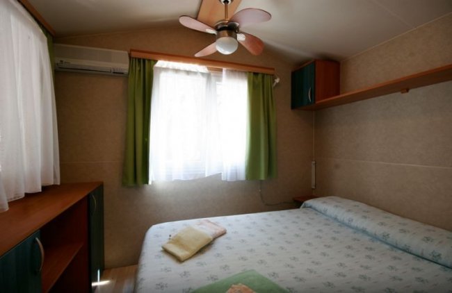 Camera con letto matrimoniale e ventilatore.