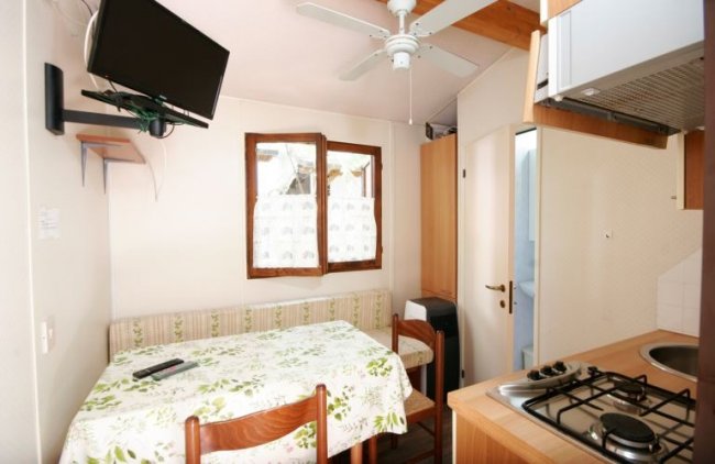 Interno con tavolo, TV e cucina.