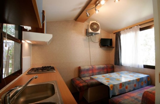 Interno di un bungalow con cucina e tavolo.