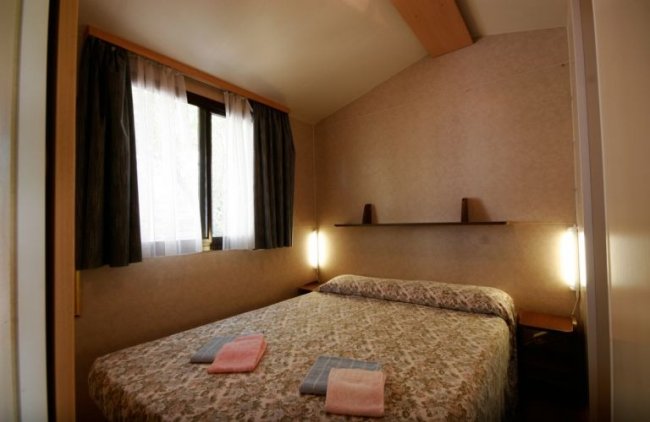 Camera da letto semplice con letto matrimoniale.