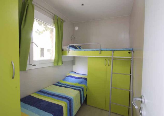Cameretta con letto a castello e guardaroba verde.