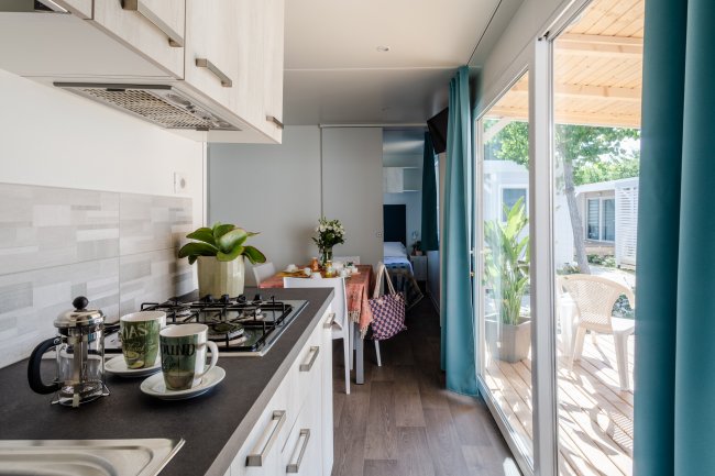 Cucina moderna con tavolo apparecchiato e vista sul patio.