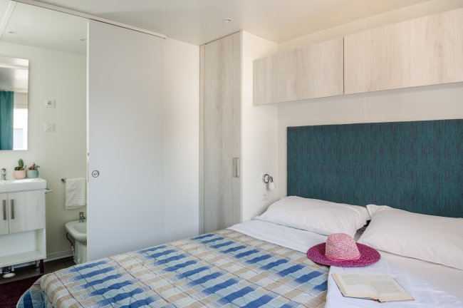 Camera da letto con letto matrimoniale e cappello rosa.