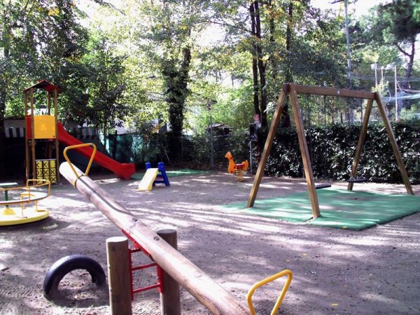 Un parco giochi all'aperto con altalena, scivoli e altre attrezzature.